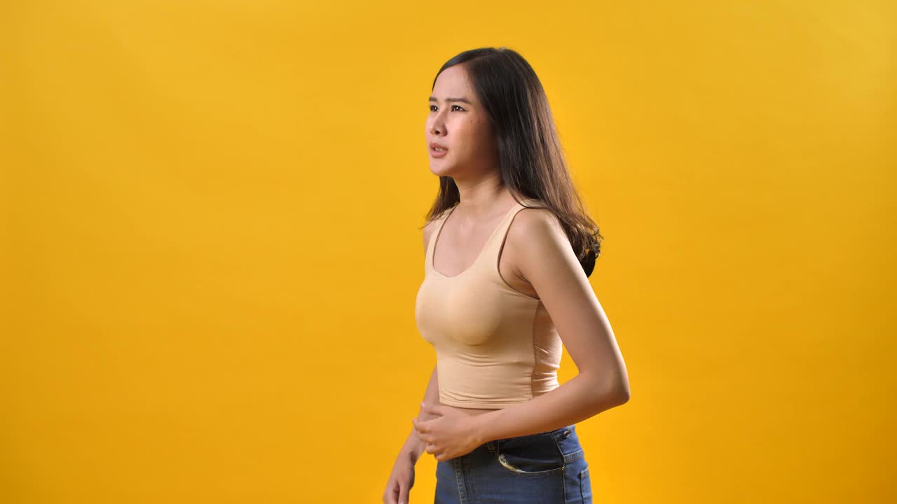妇女胃痛痛分离在黄色背景上视频素材