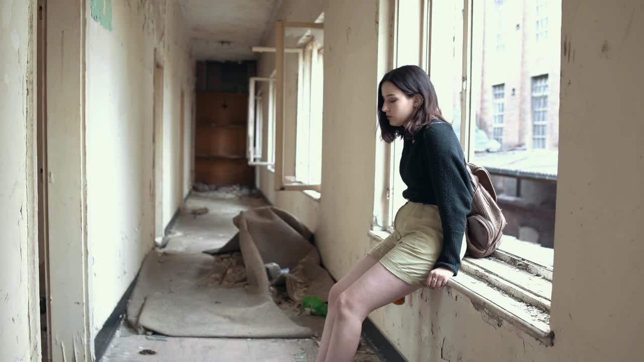 一个抑郁的女人在废弃的大楼里视频素材