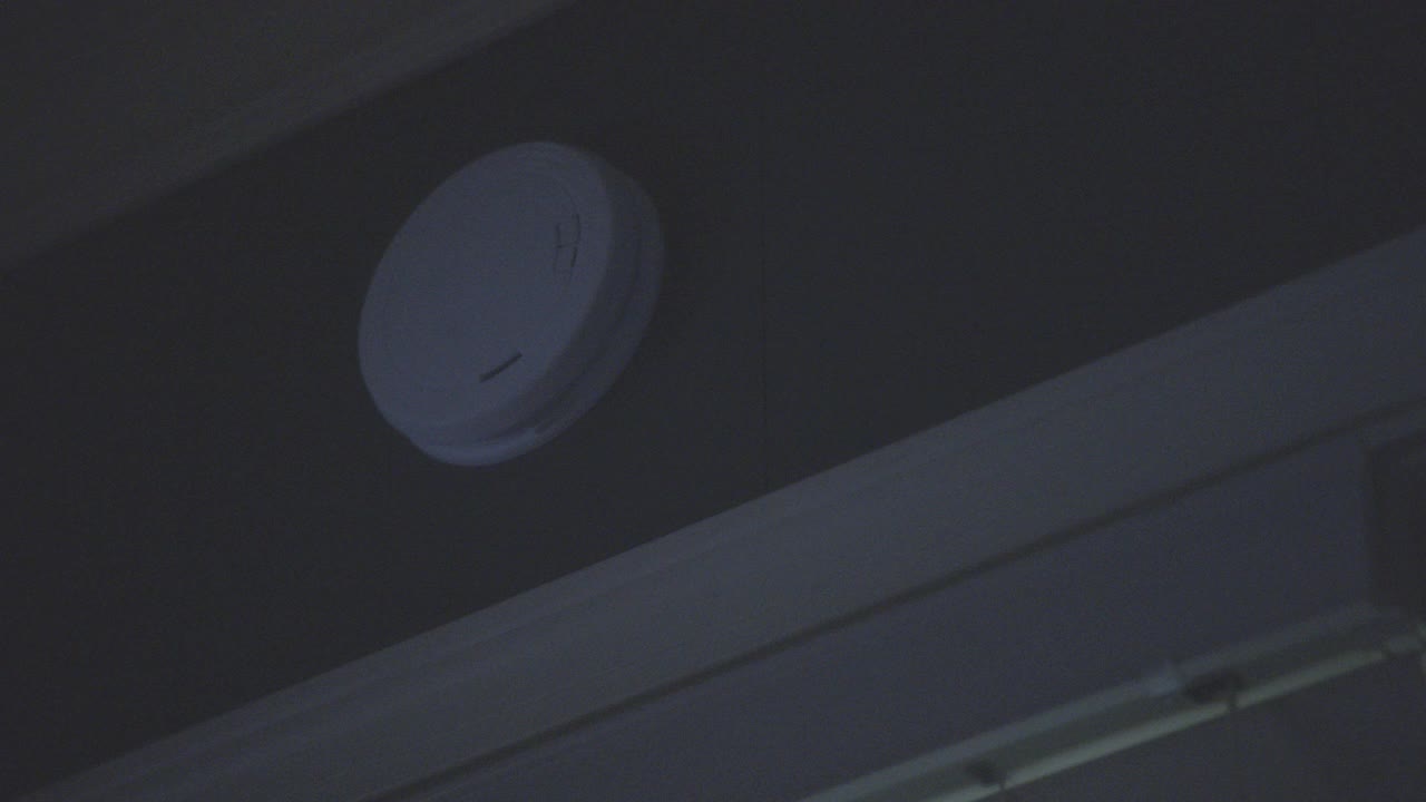 房屋或公寓烟雾探测器或报警器的上角。门框部分可见。红灯闪烁报警。视频下载