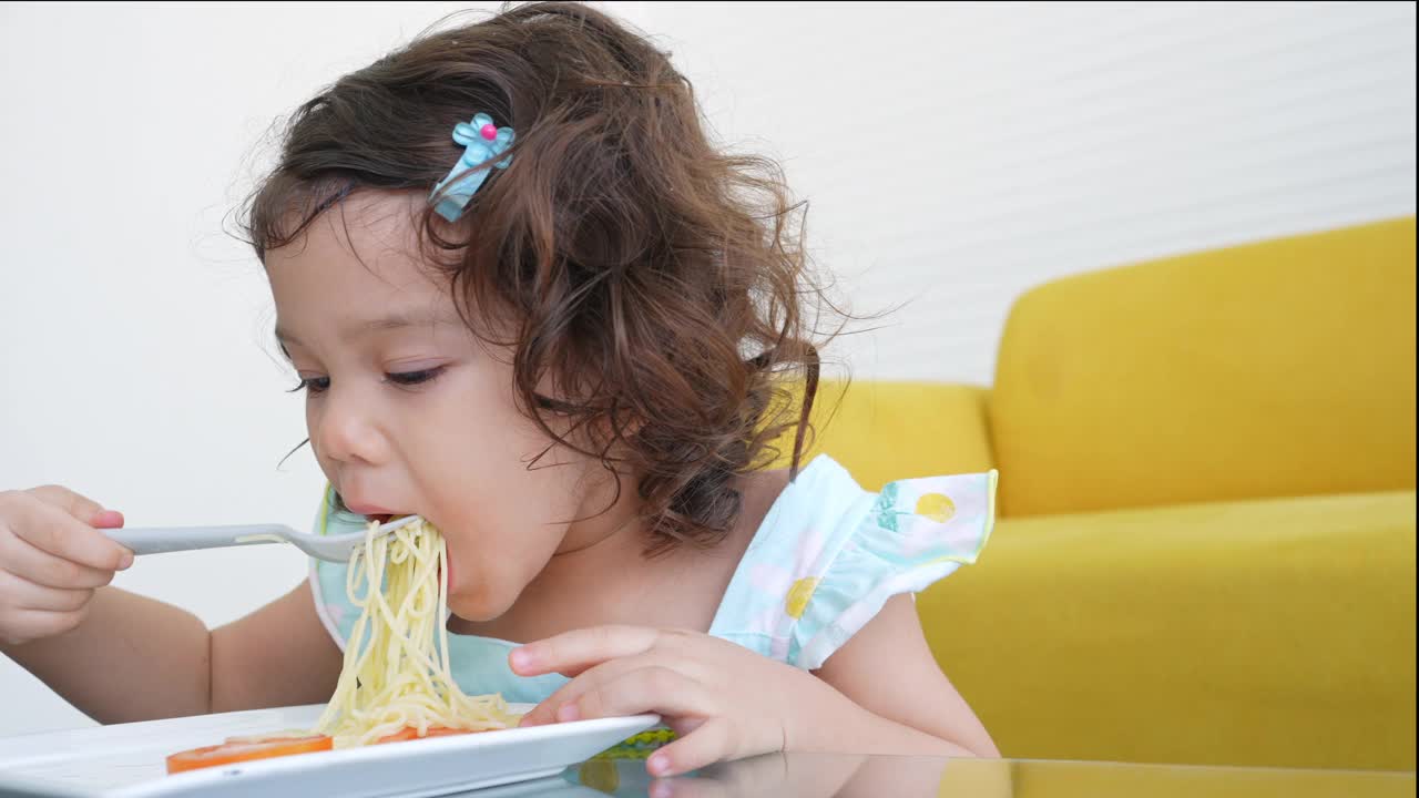 小女孩在桌子上吃意大利面视频素材