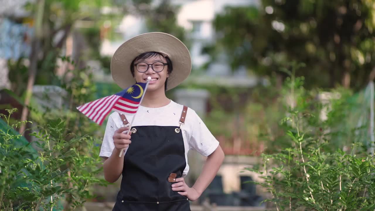 亚洲华人少年戴着口罩在自家农场挥舞国旗视频下载