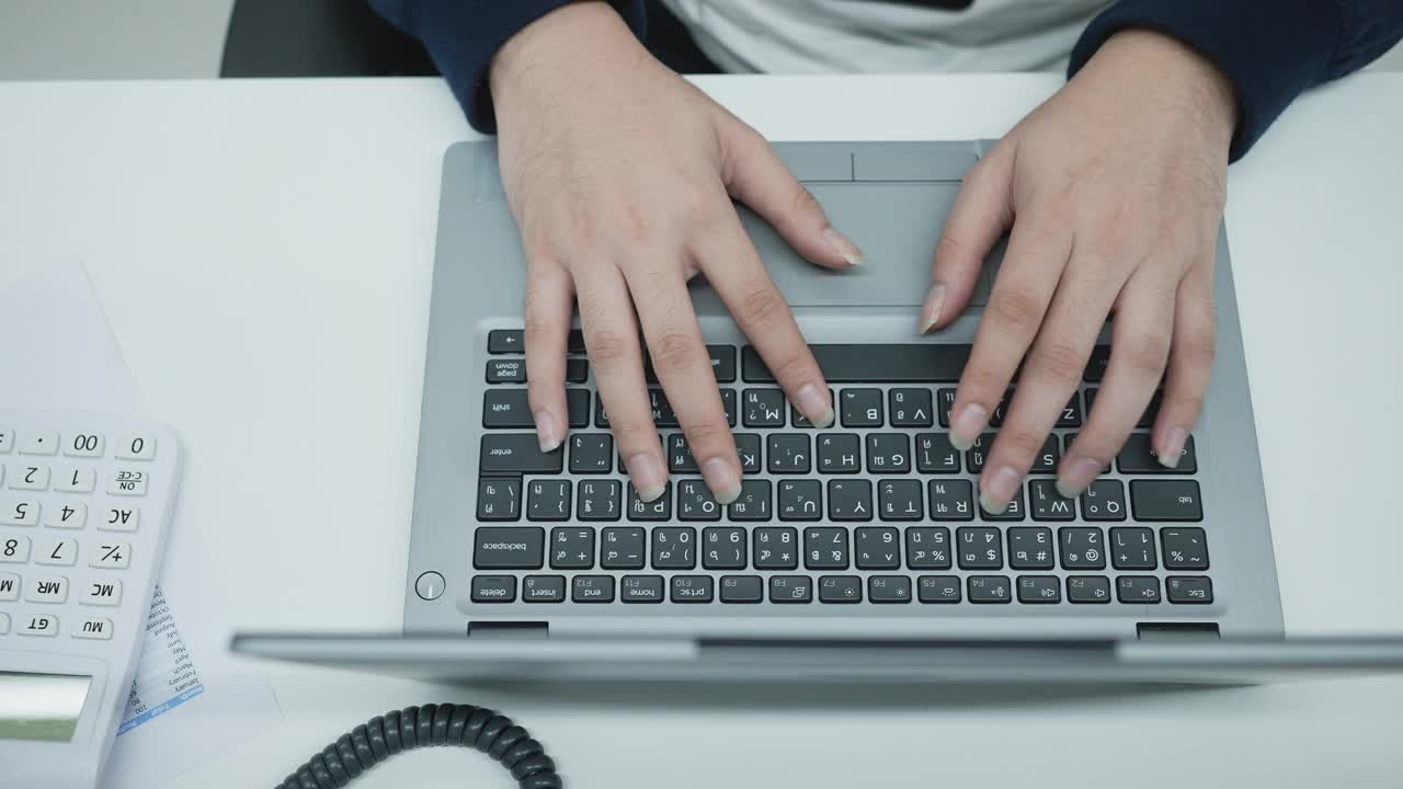 慢动作俯视图场景的会计人员在办公室使用计算机计算总结统计和在笔记本电脑上打字作报告的业务和财务概念视频素材