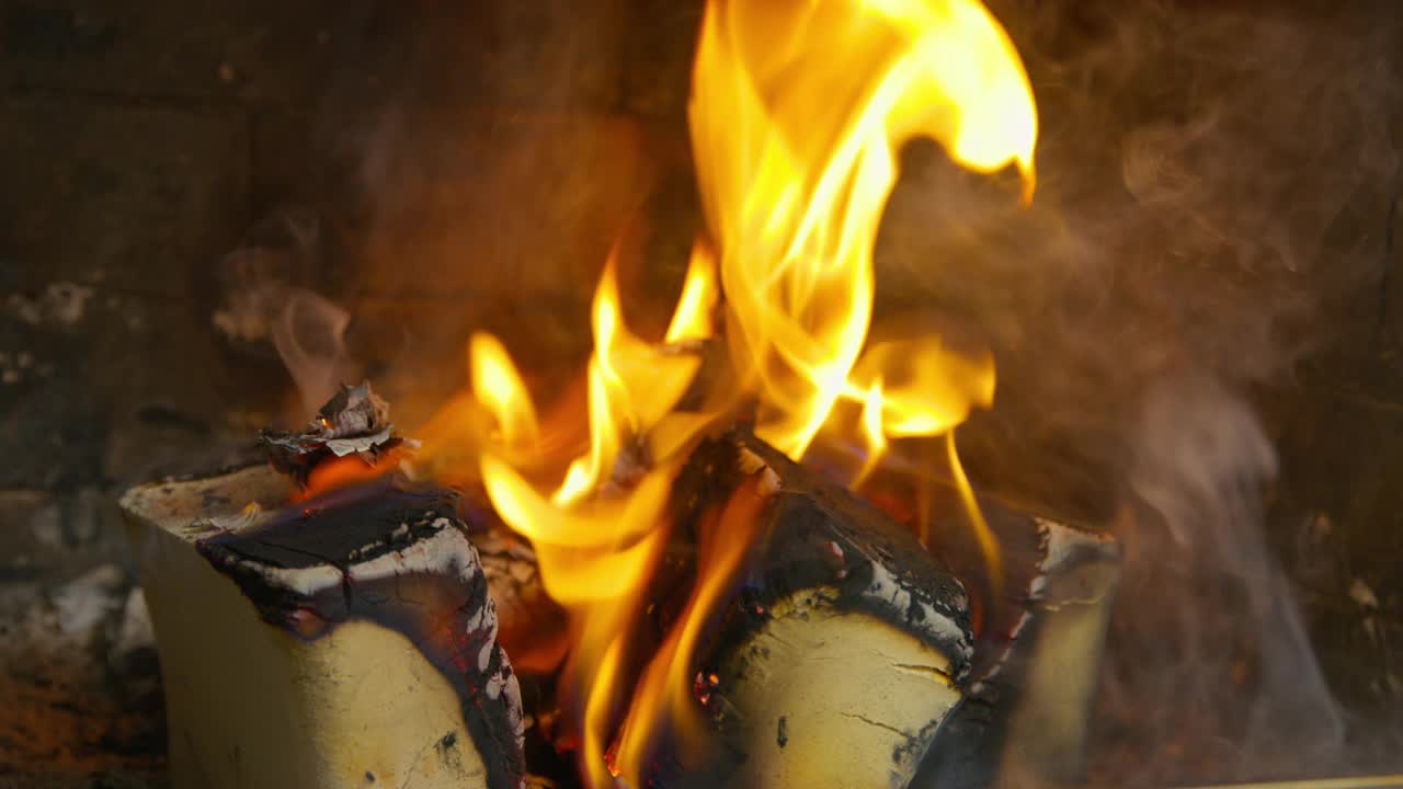 火在近距离的壁炉里燃烧。用火砖在石头壁炉里燃烧木柴视频素材