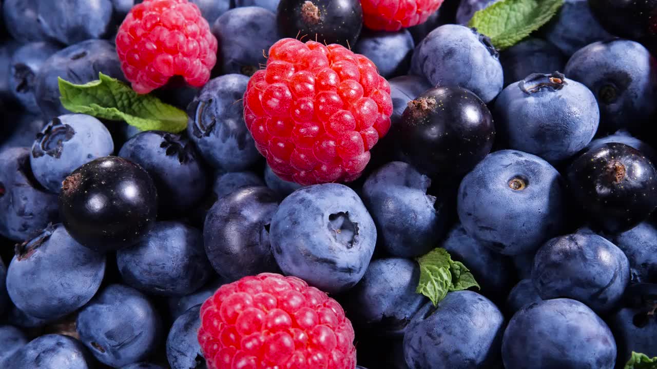 浆果，各种丰富多彩的背景，多汁成熟的夏季浆果。薄荷叶，覆盆子，蓝莓特写，生物水果，健康饮食，素食食品，饮食。4 k UHD视频视频素材