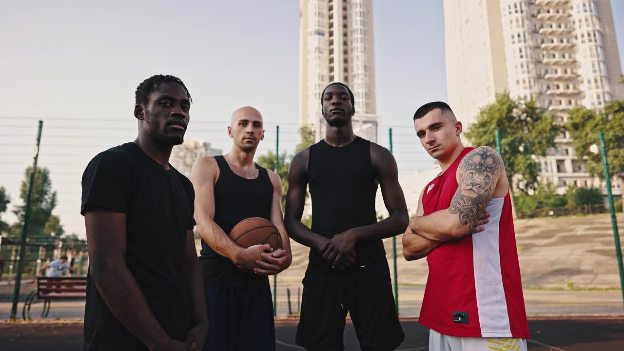 篮球队。放大篮球场上多种族运动员队伍的照片。朋友:白人和非洲裔，穿着运动服，拿着篮球视频下载
