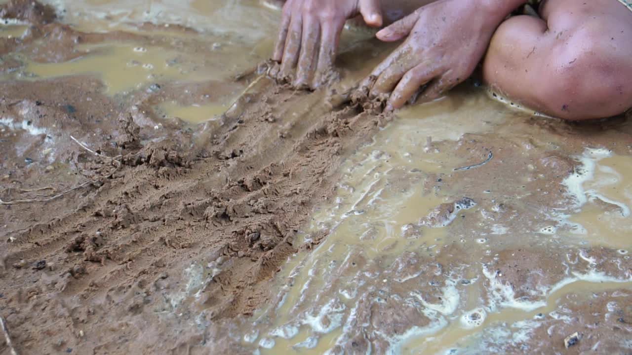 贫困的孩子们在泥泞的水里快乐地玩耍视频素材