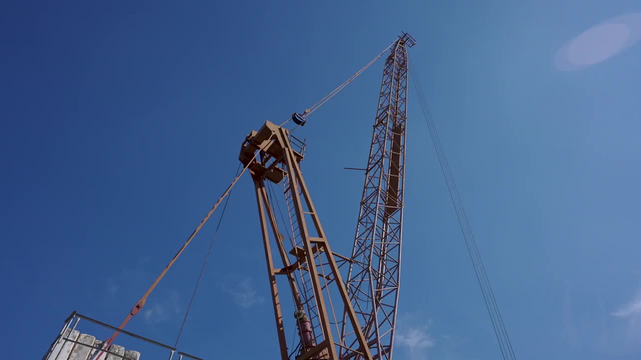 在晴朗的日子里，大型吊车用来将水泥混凝土平台吊到高层建筑的屋顶。视频素材