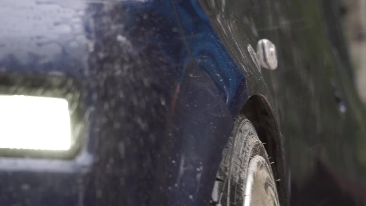 一颗水滴在跑车上的特写镜头。镜头。洗车的特写镜头。视频下载
