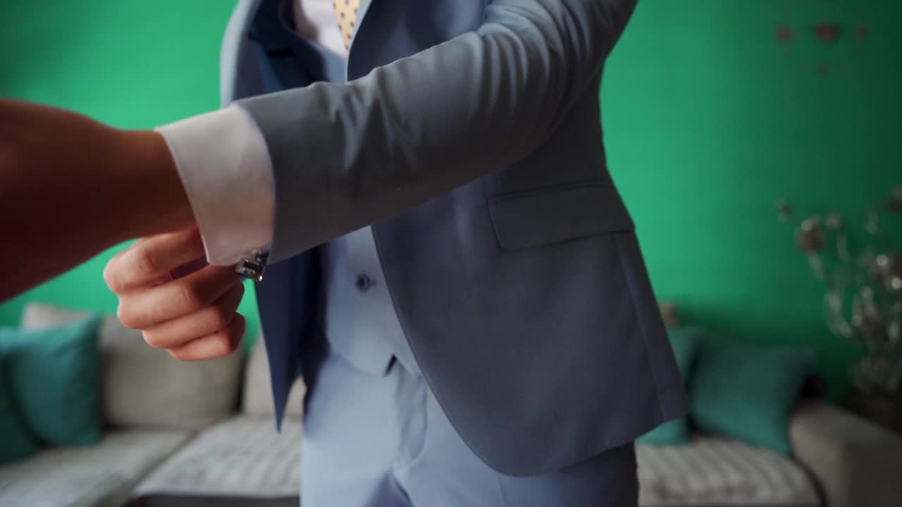 优雅的新郎扣上衬衫袖口，为他的婚礼盛装视频下载