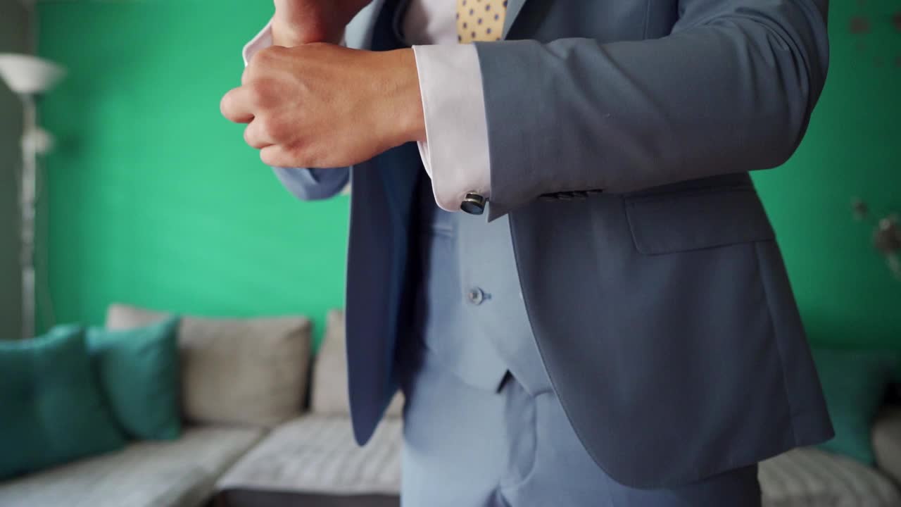新郎正在调整衬衫袖子的袖口，以确保他在婚礼这人生中重要的日子里看起来优雅视频下载
