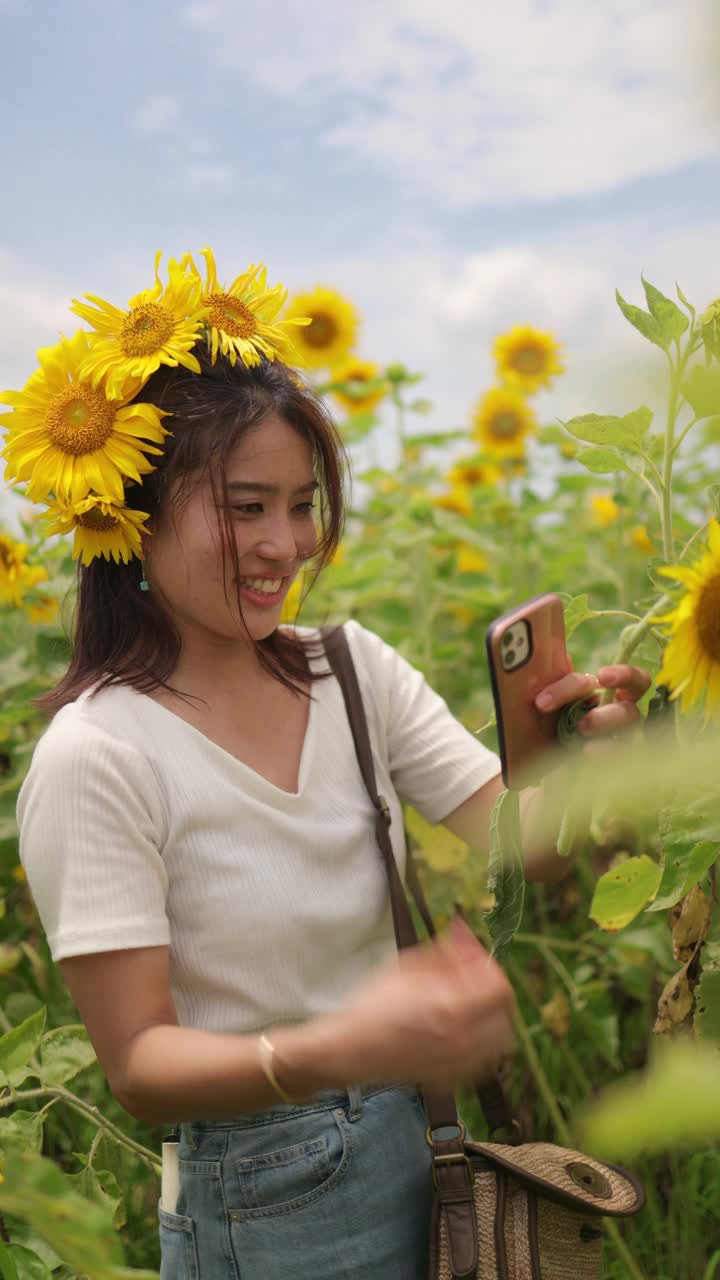 快乐的女人头上戴着真正的向日葵在向日葵地里享受视频下载