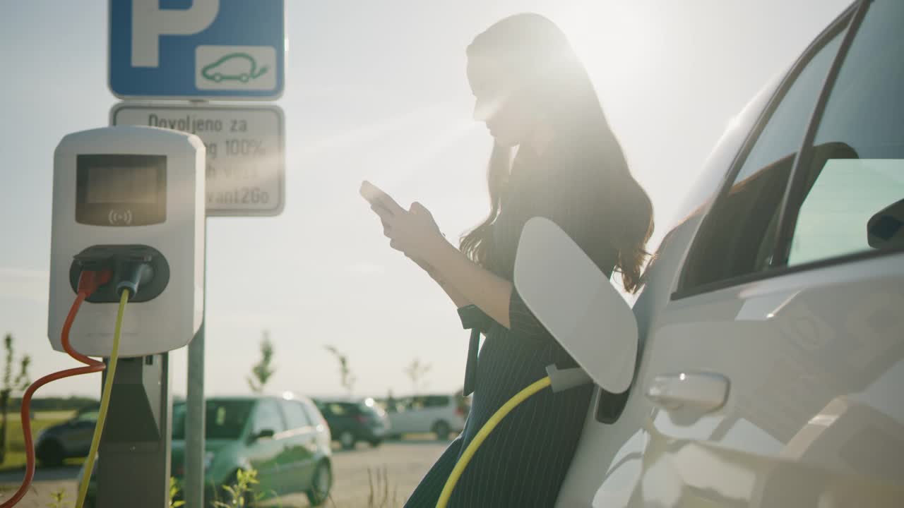 一位年轻女子在等车充电时使用智能手机视频下载