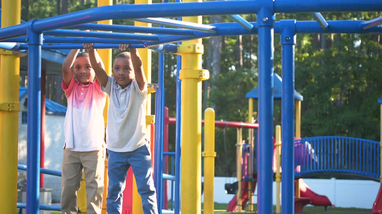 非裔美国双胞胎男孩在单杠上玩耍视频下载