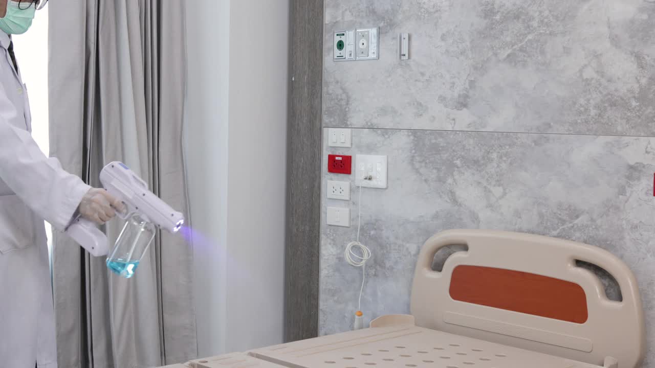医生喷洒酒精消毒剂来清洁病人的床。视频素材