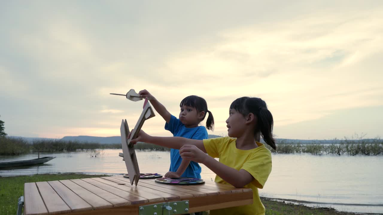 兄弟姐妹在夕阳下玩木飞机的场景，谁想追随梦想视频素材