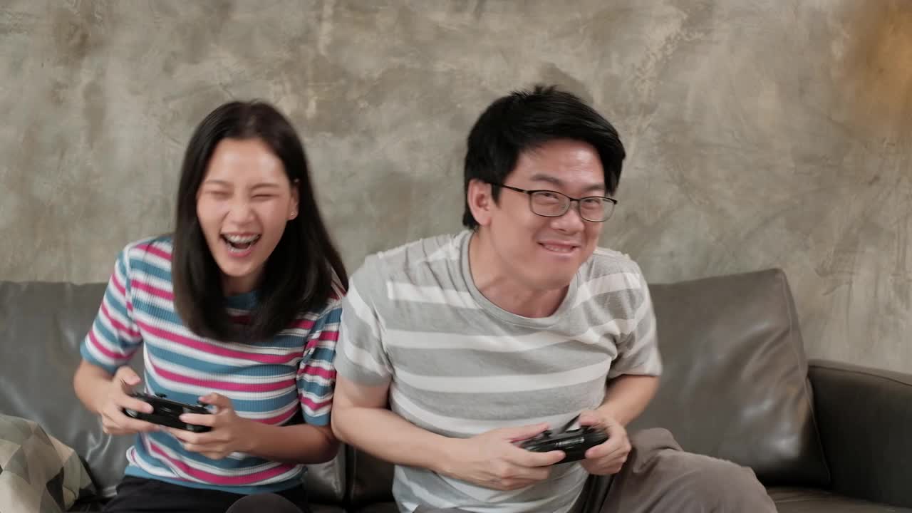 亚洲男子和女友玩游戏机玩得很开心。视频素材