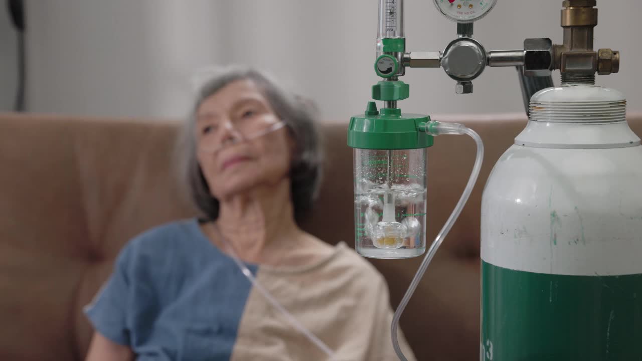 老年妇女在家中佩戴氧气鼻导管。视频素材