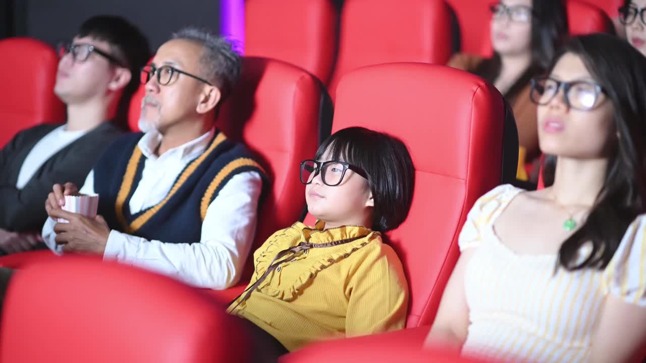 一群中国观众带着3D眼镜在电影院观看3D电影视频下载