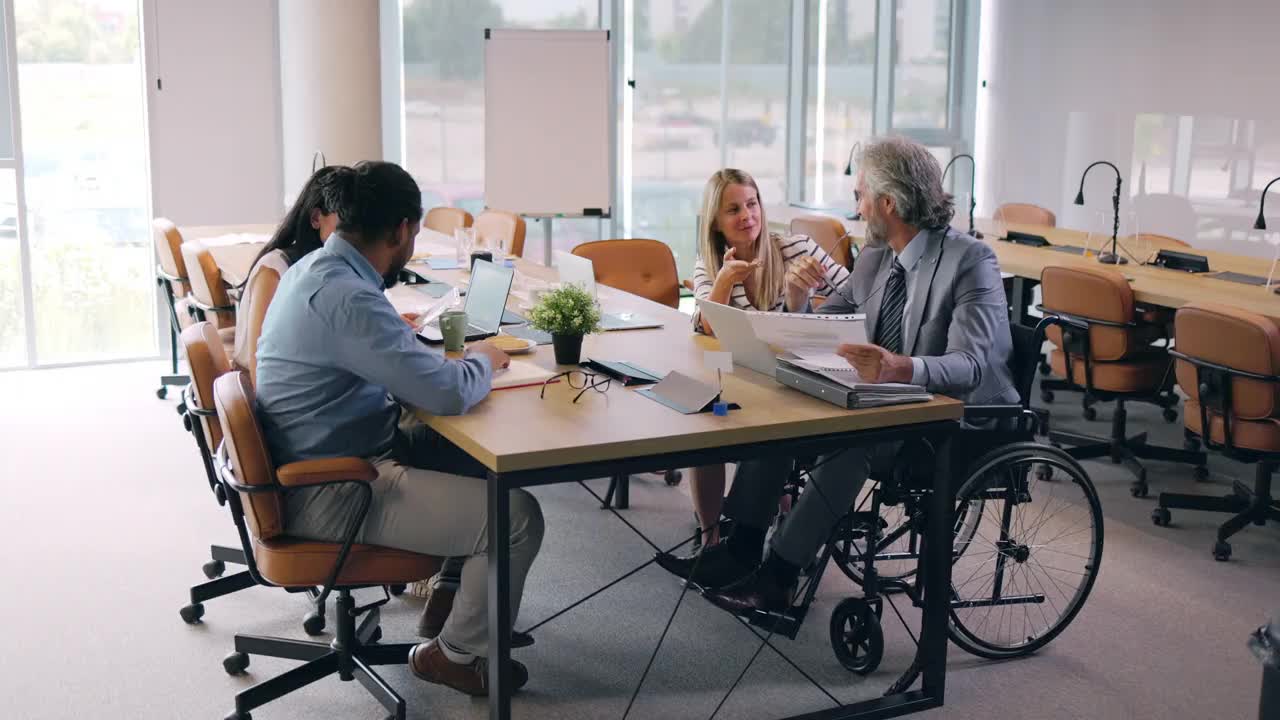轮椅商人在创意办公室领导小组讨论视频素材