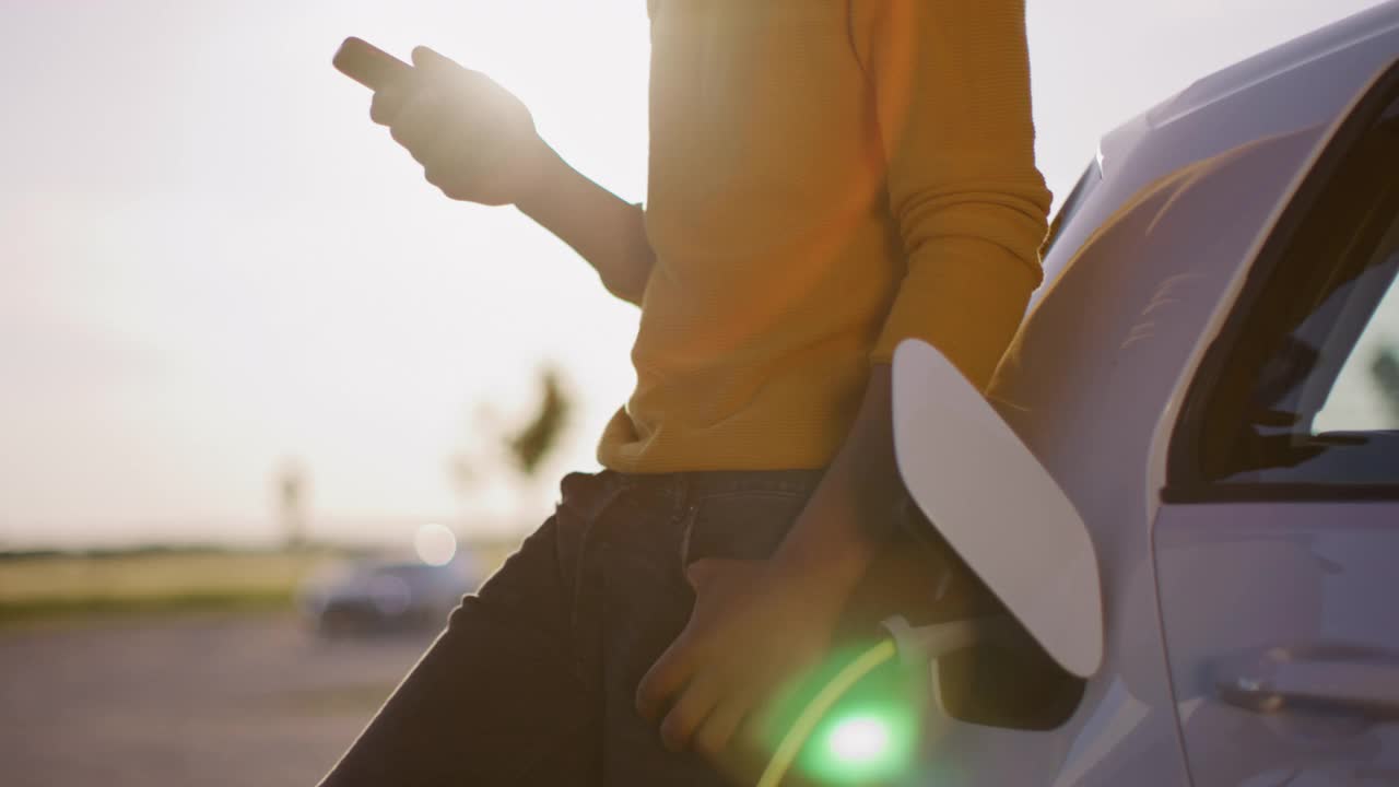 一名陌生男子在停车场充电时使用智能手机视频素材