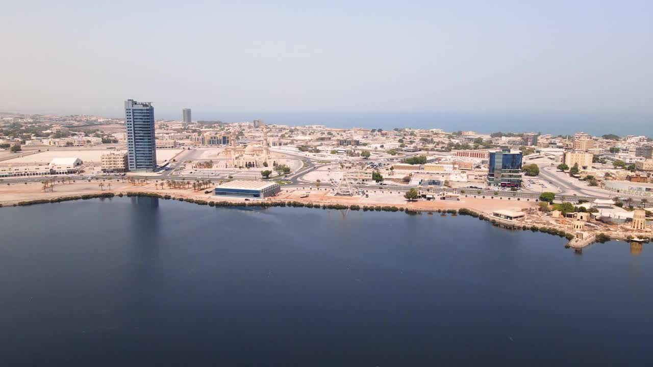 拉斯al Khaimah海滨大道和酋长国的市中心地区的空中城市景观，地标性的天际线，摩天轮和一座清真寺视频素材