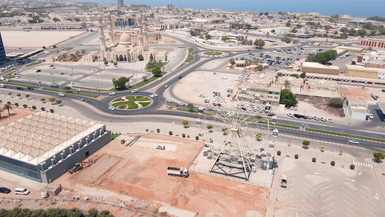 拉斯al Khaimah海滨大道和酋长国的市中心地区的空中城市景观，地标性的天际线，摩天轮和一座清真寺视频素材