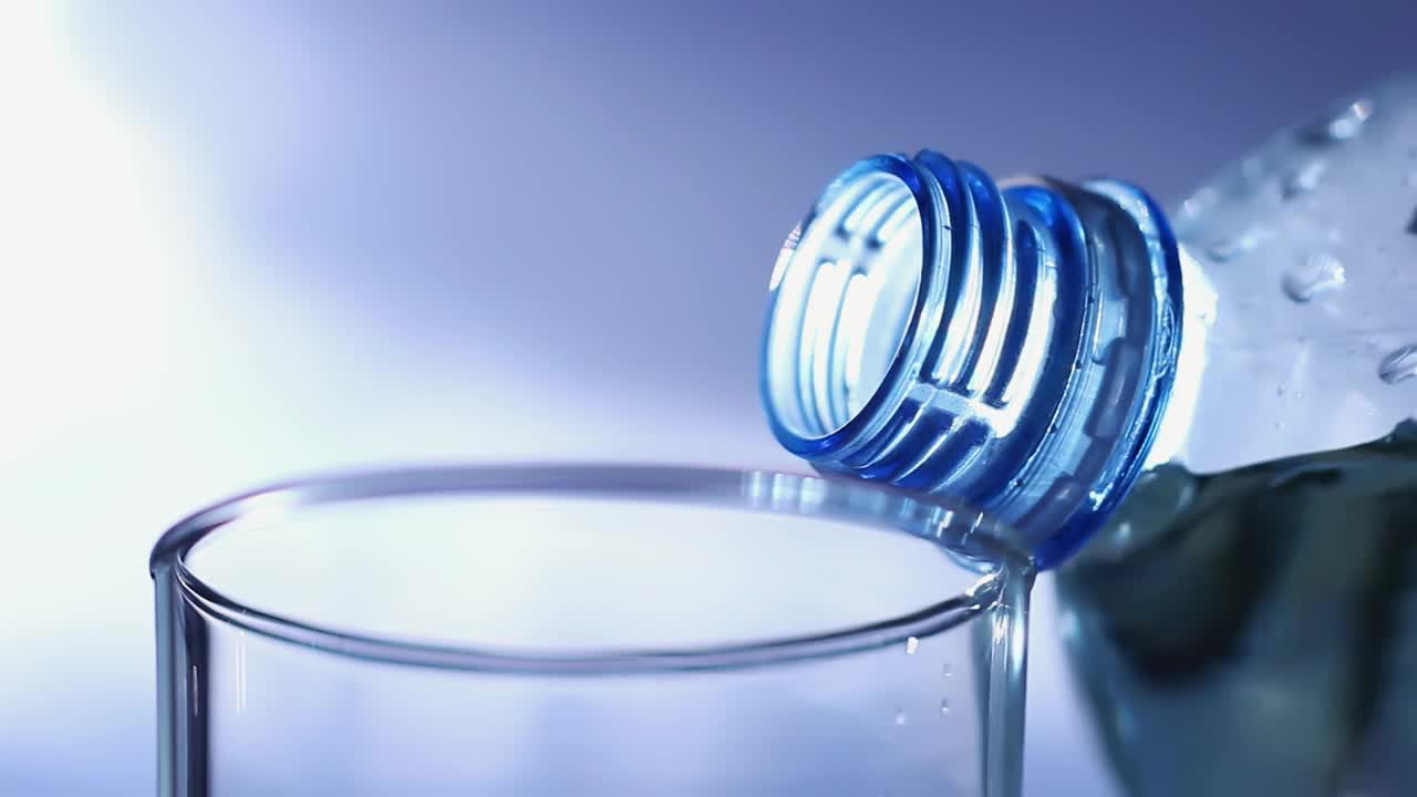蓝色背景下的透明塑料水瓶视频素材