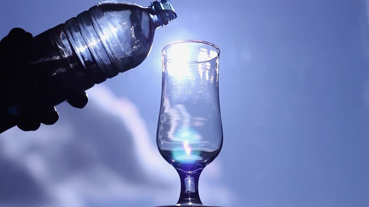 把饮用水倒进玻璃，衬蓝天视频素材