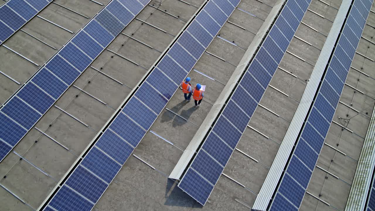 两个电工正在检查屋顶发电厂的光伏板视频素材