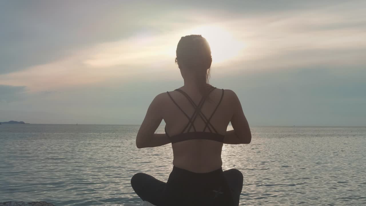 女人坐着，用瑜伽放松视频素材