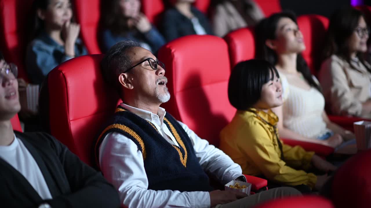 一位亚裔中国老人和他的孙女在电影院看电影时睡着了视频素材