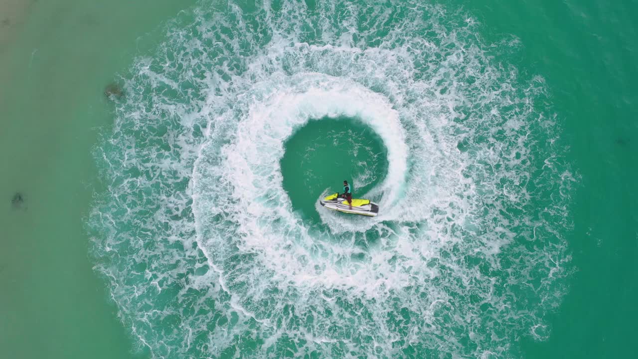 人们在海里玩水上摩托艇。鸟瞰图。前视图。神奇的自然背景。水的颜色又美又亮。新鲜的自由。冒险的一天。热带海滩上清晰的蓝绿色视频下载