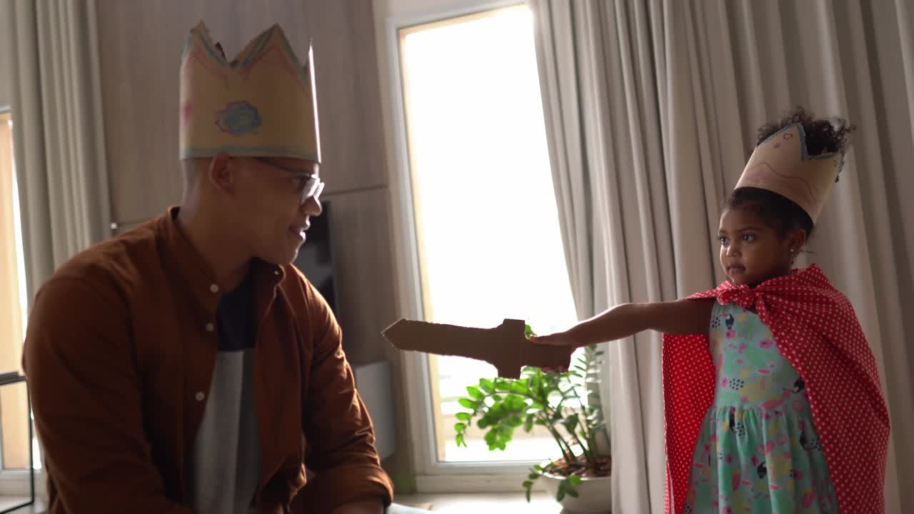 父亲和女儿在家里戴着皇冠玩耍的肖像视频素材