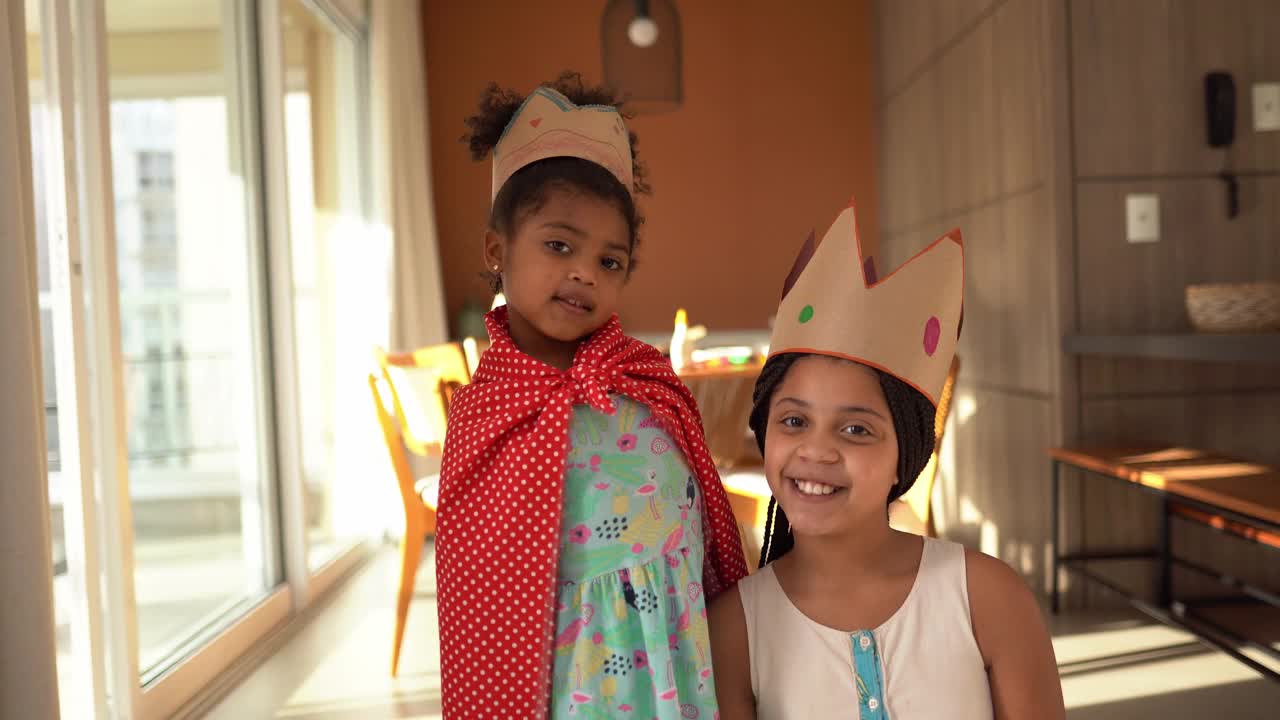 可爱的姐妹们在家里戴着皇冠玩耍视频素材