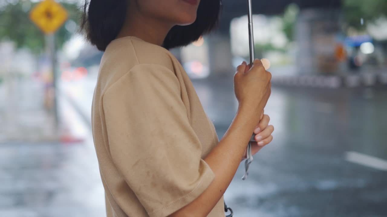 女人在雨中撑伞的慢动作视频下载