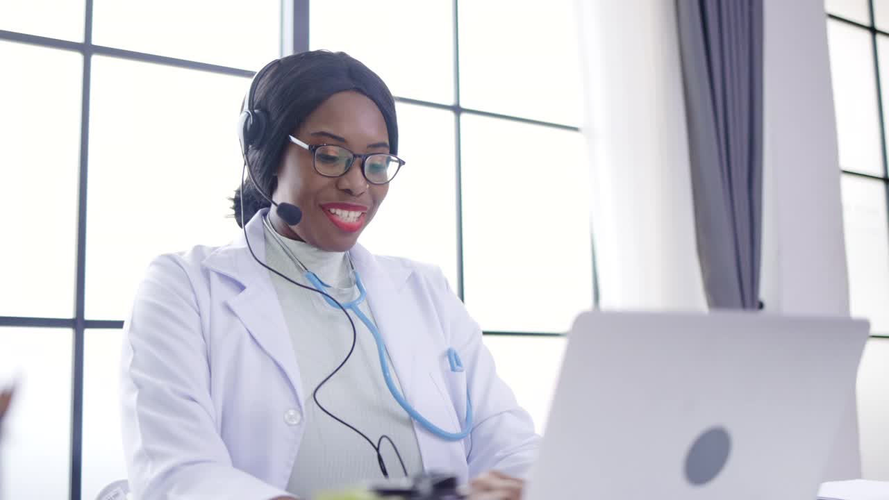 非裔美国医生戴着耳机在医院视频通话服务与远程病人通话。医疗咨询。与同事进行网络研讨会。远程保健和远程医疗概念。视频素材