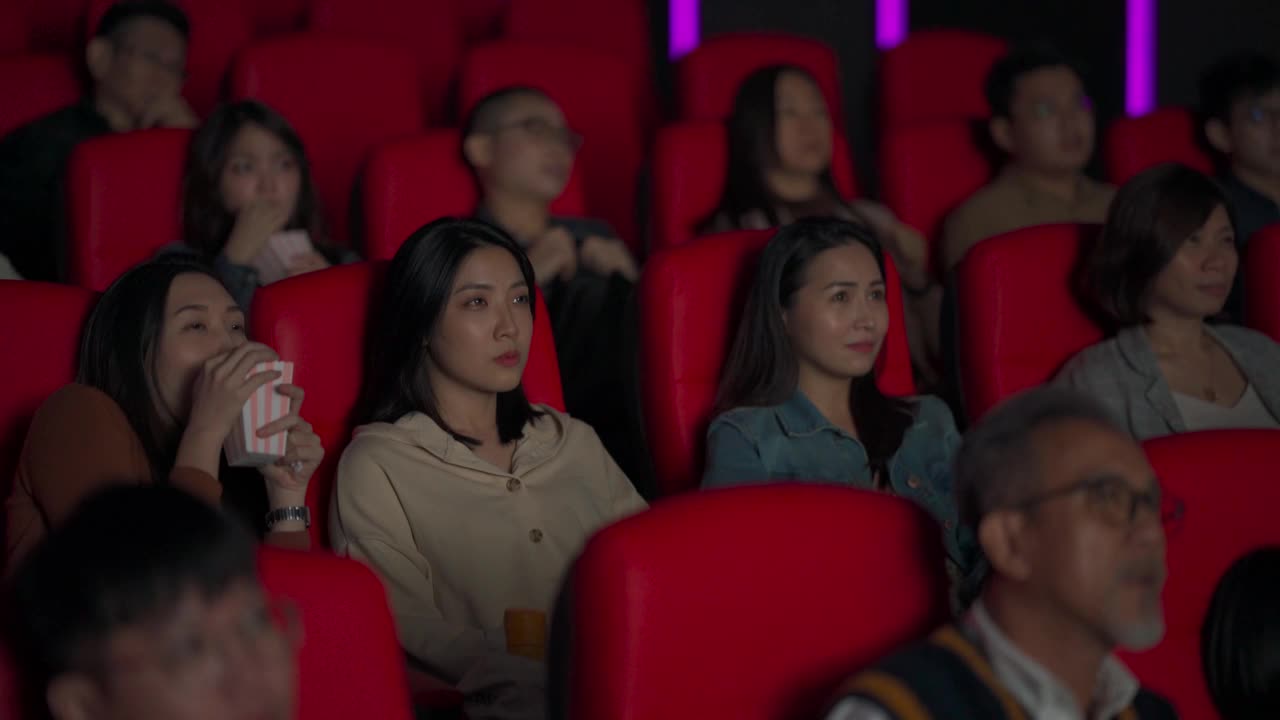 一群亚洲华人在电影院看恐怖的恐怖片视频下载