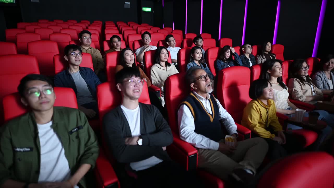 广角的亚洲华人群在电影院看喜剧电影笑视频下载