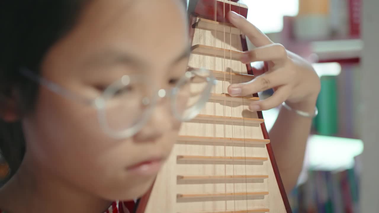 小女孩在弹琵琶(中国的琵琶，一种带有微动指板的拨弦乐器)视频下载