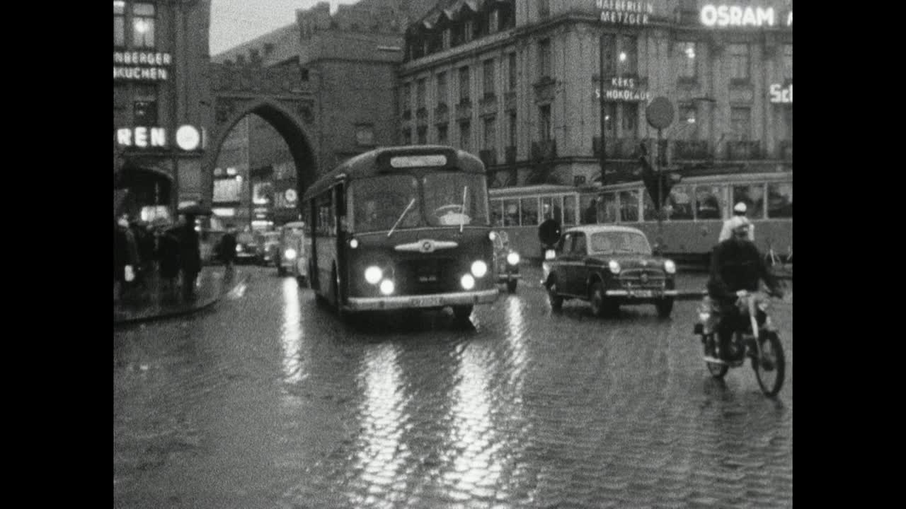慕尼黑，穿着大衣的妇女在雨中等待有轨电车;1966视频素材