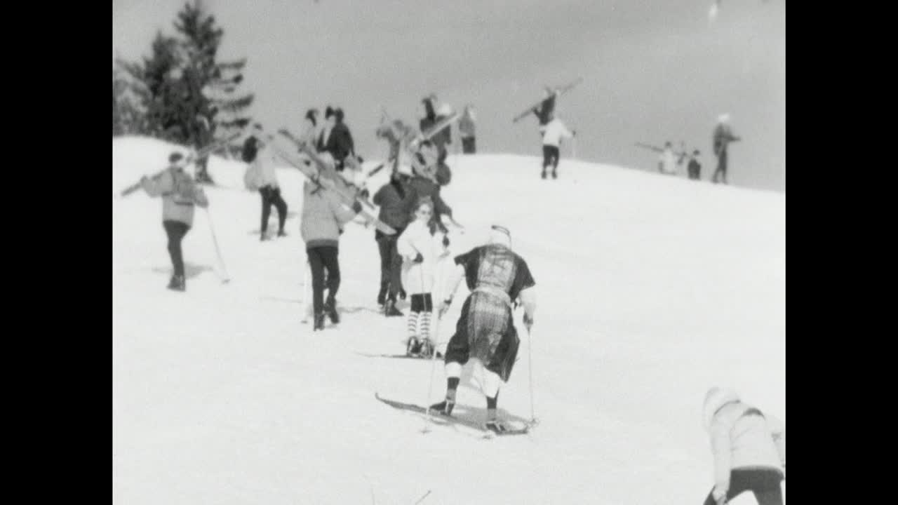 宿醉的人在Fasching期间穿着戏服爬滑雪坡;1966视频素材