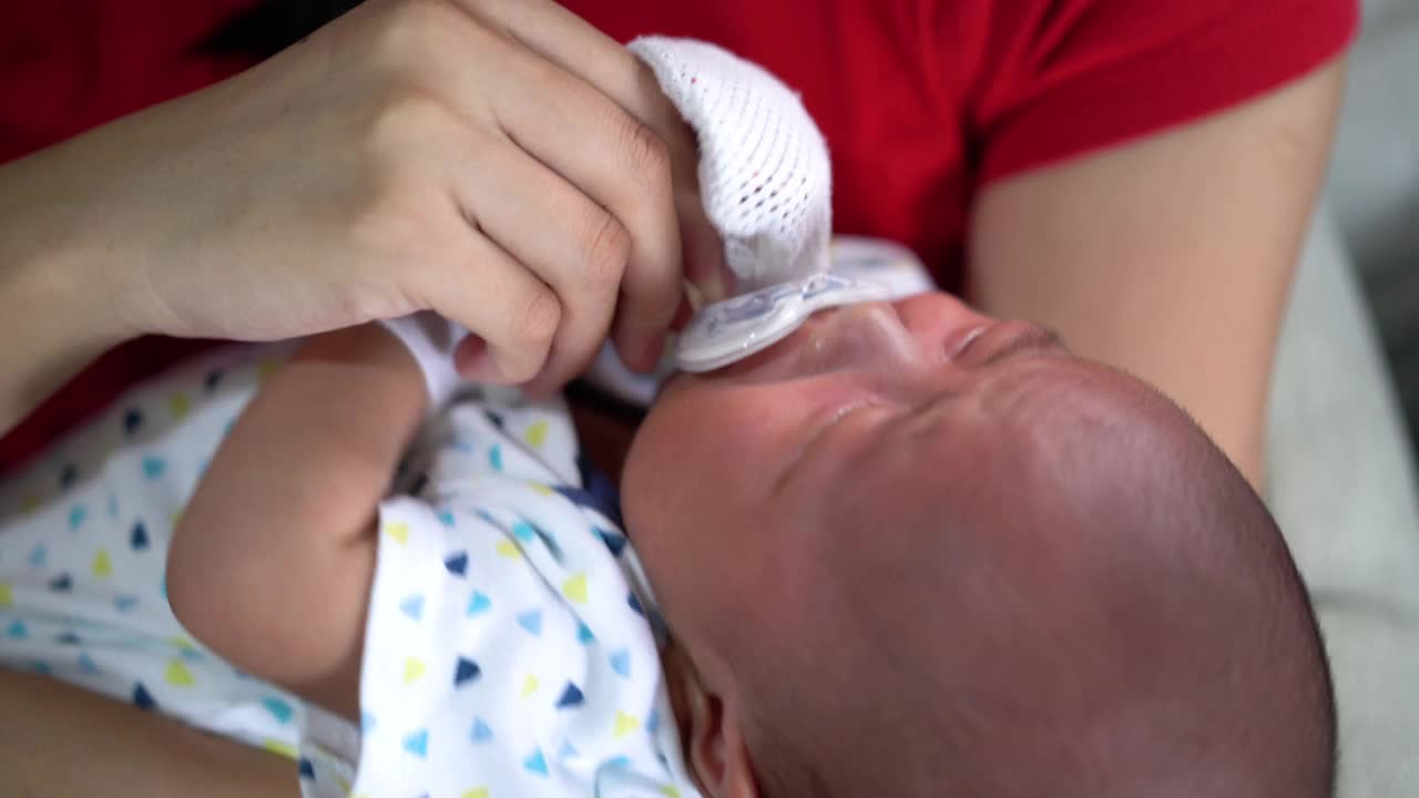 一位亚洲妇女给她的新生儿奶嘴视频素材