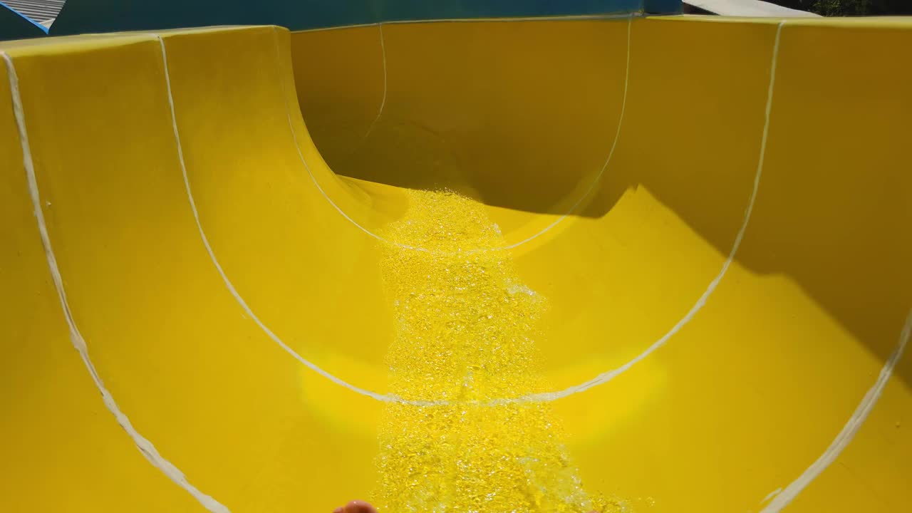 在度假胜地的水上公园里，人们的脚滑下水池，享受着夏日的滑水道视频下载