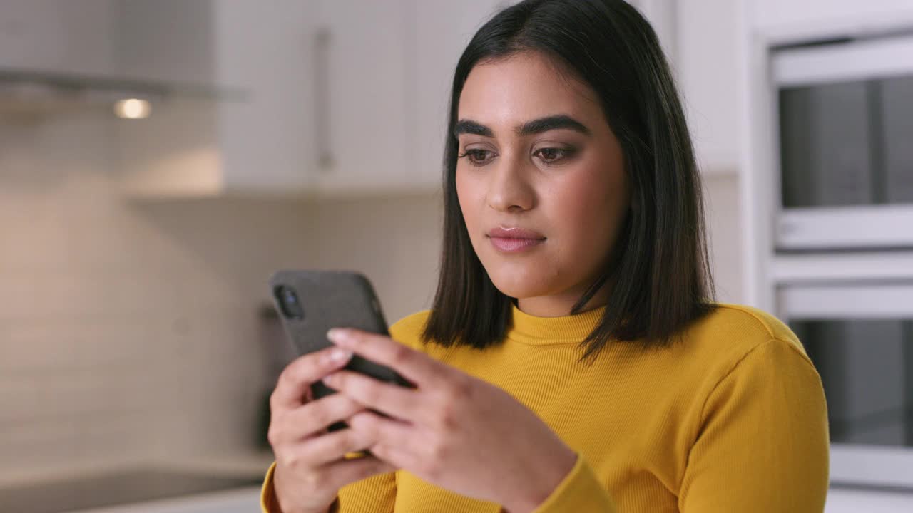 一段4k视频显示一名年轻女子在家里使用智能手机，看起来很震惊视频下载