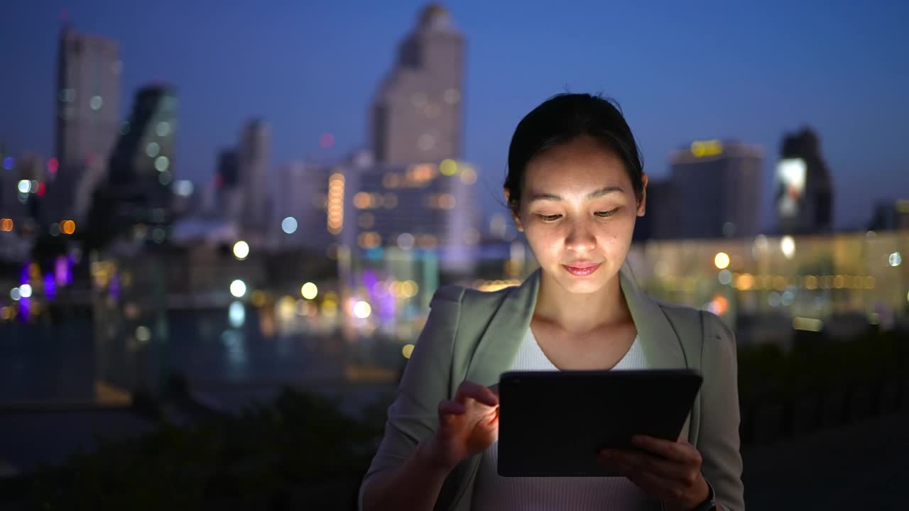 亚洲女商人在晚上使用智能设备视频素材