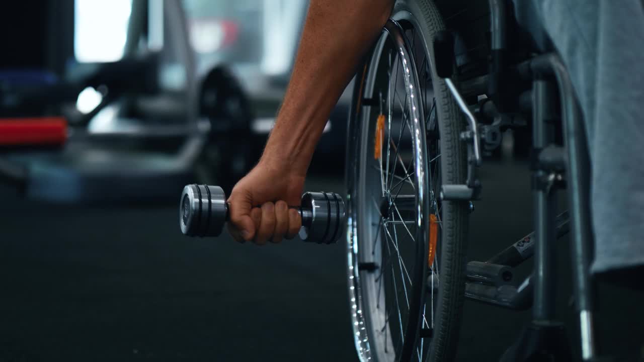 特写视频残疾人轮椅老人用哑铃锻炼身体，残疾人。视频下载