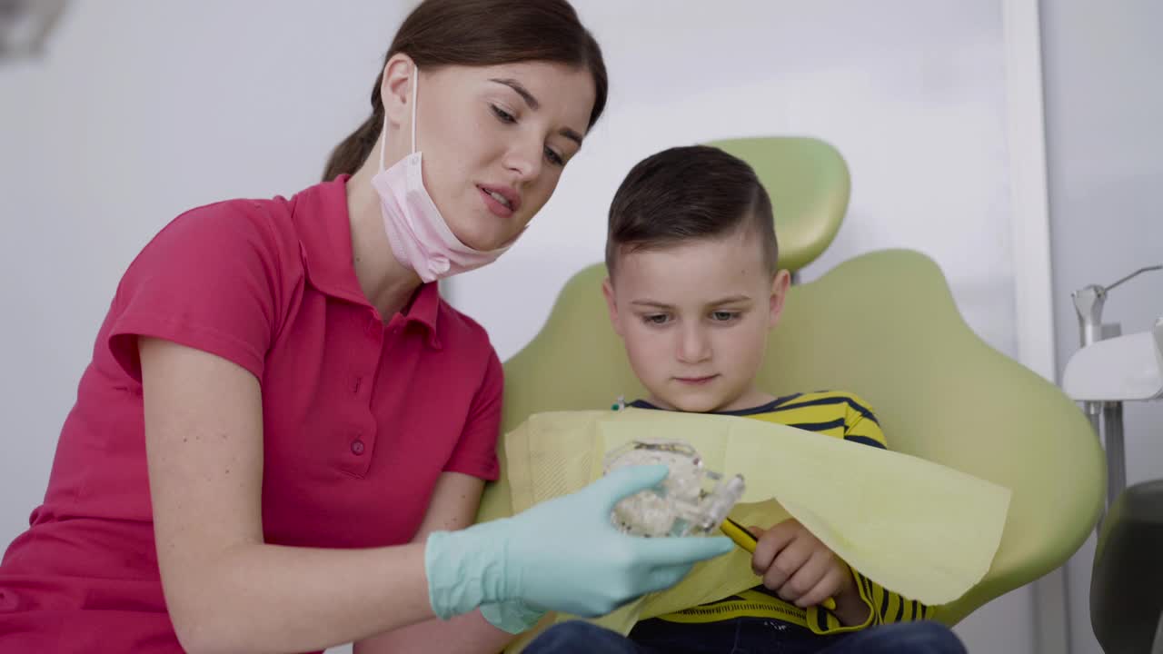牙医向孩子展示如何正确使用牙刷和下颌布局刷牙视频素材
