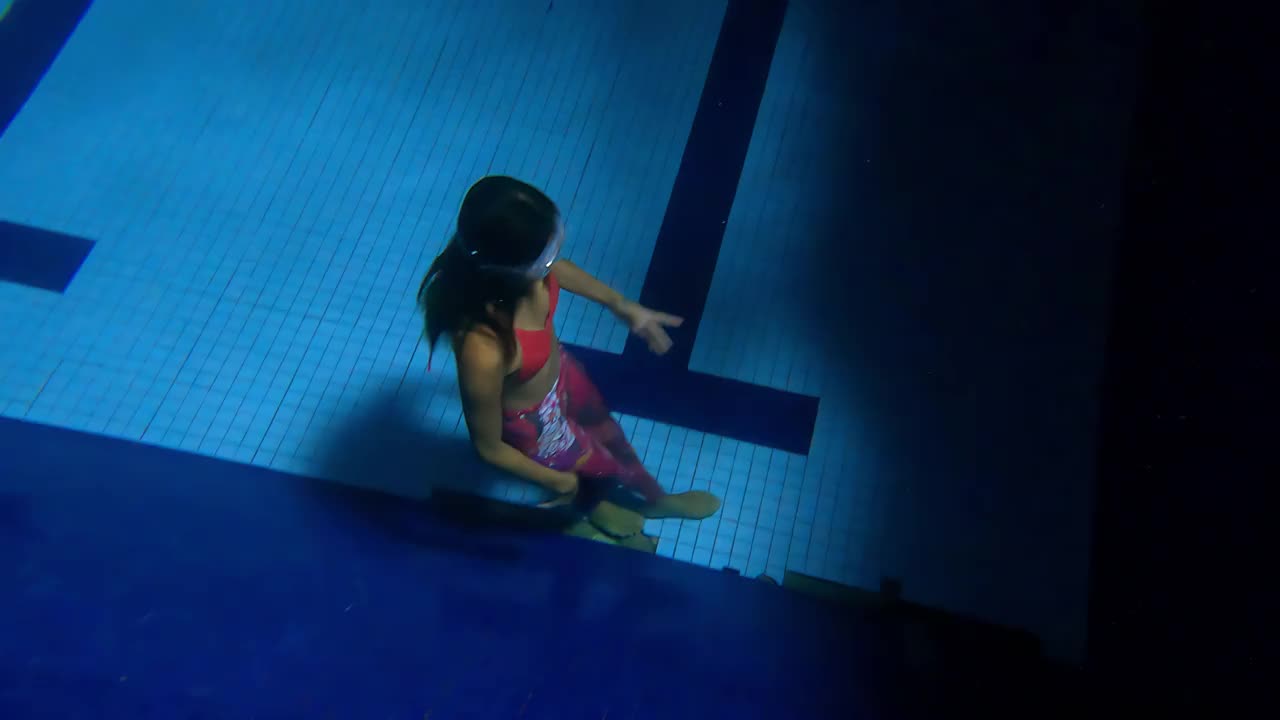 亚洲中国女游泳运动员跳水入水，从池底上浮视频素材