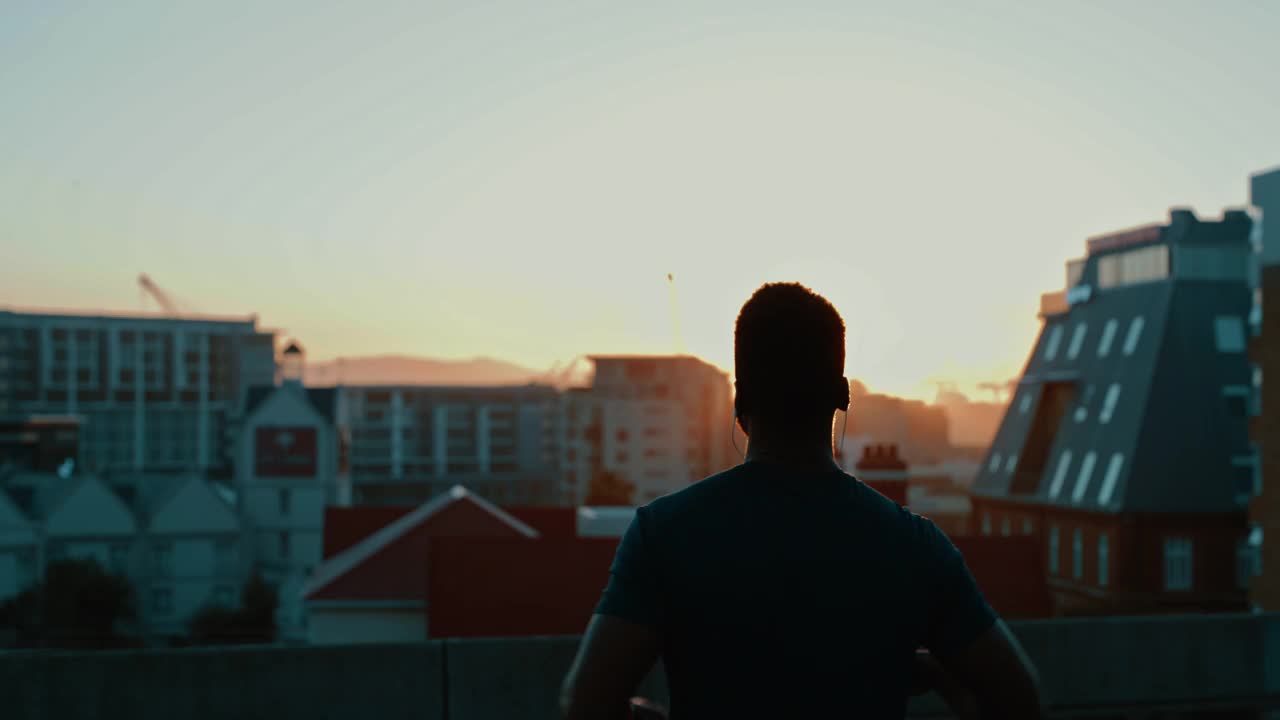 一名年轻人在日落时分在城市里锻炼时欢呼的4k视频片段视频素材