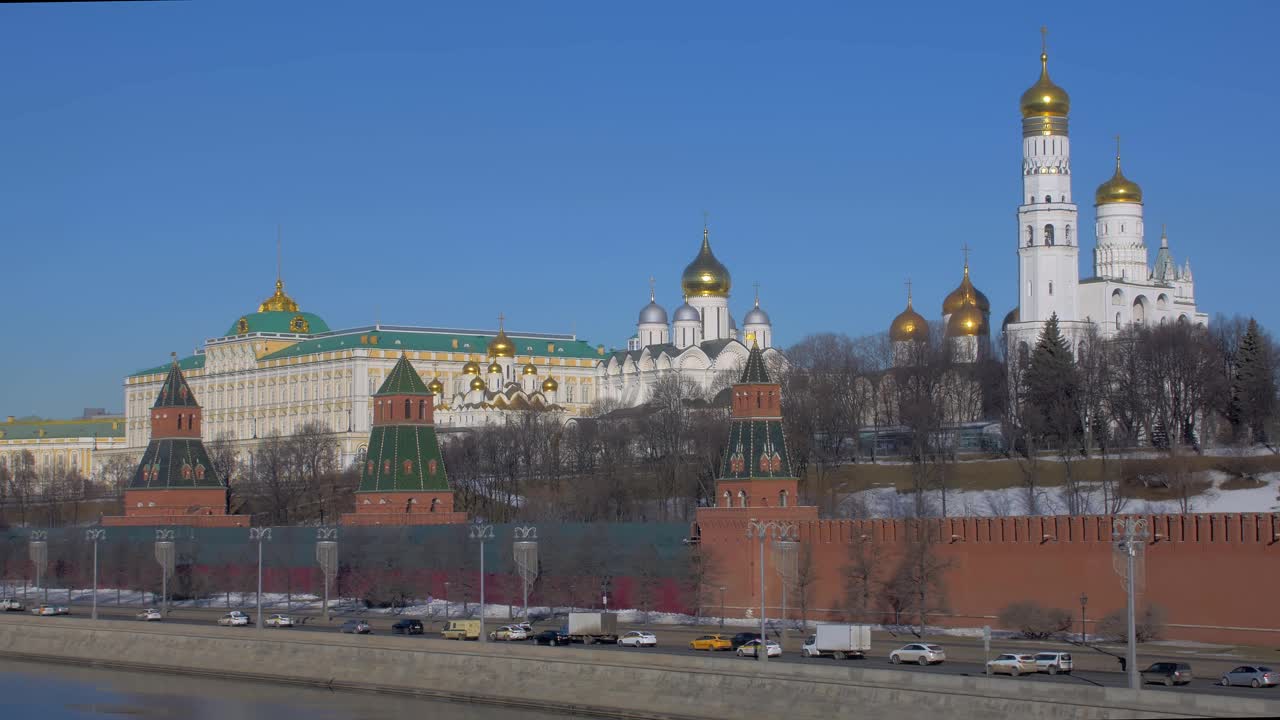 克林姆林宫和莫斯科的教堂一起，汽车在俄罗斯首都的河堤上行驶视频下载